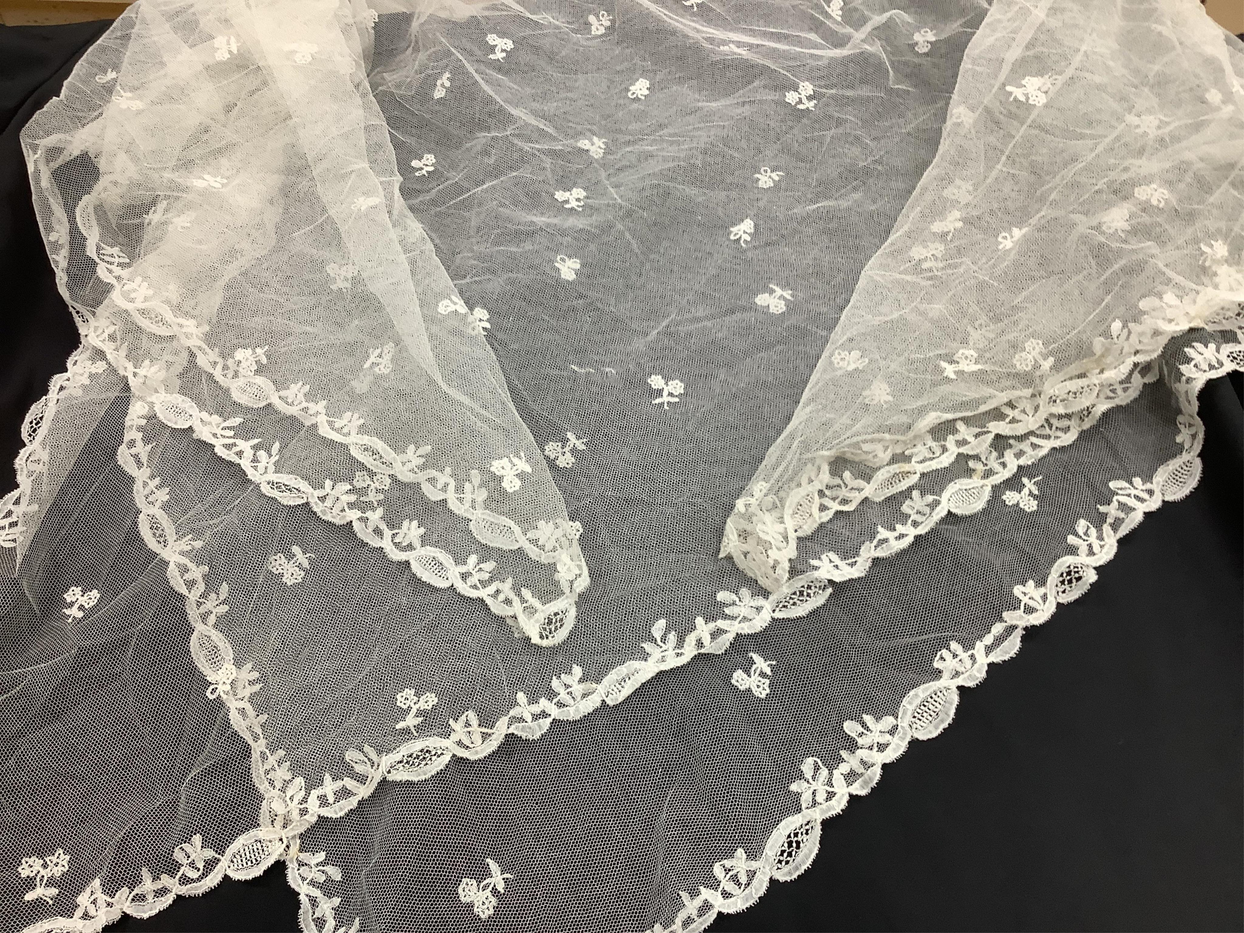 A small late 19th century Brussels wedding veil, an earlier Brussels bobbin bonnet veil, two needle run bonnet veils, various lace sleeves and a lilac silk and lace coverlet., Brussels veil 140cm x 132cm. Condition - the